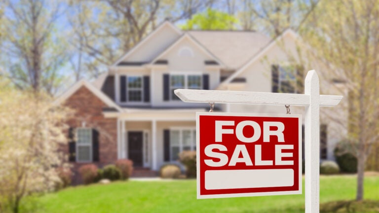 Home For Sale Real Estate Sign and Beautiful New House.